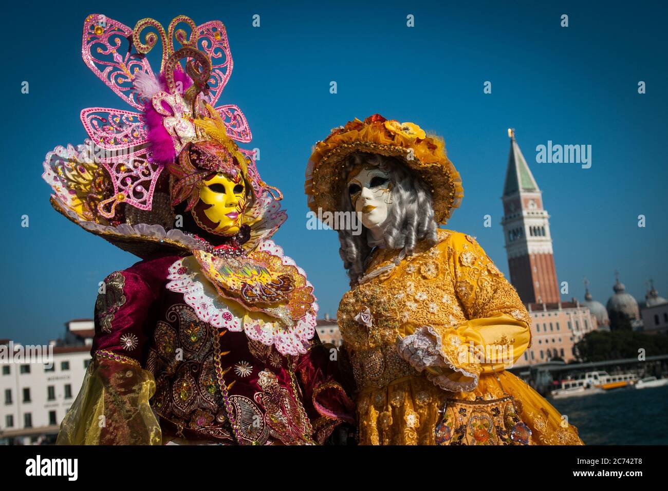 VENEDIG, ITALIEN - 28. FEBRUAR 2020: Zwei Masken posieren während des Karnevals von Venedig vor dem San Marco Becken Stockfoto