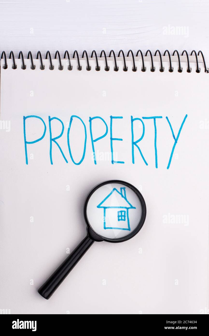 Haus und Lupe auf Notizblock. Stockfoto