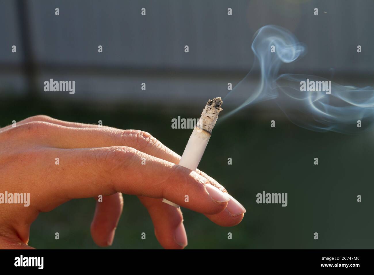 Hand eines Teenagers mit brennender Zigarette. Stockfoto