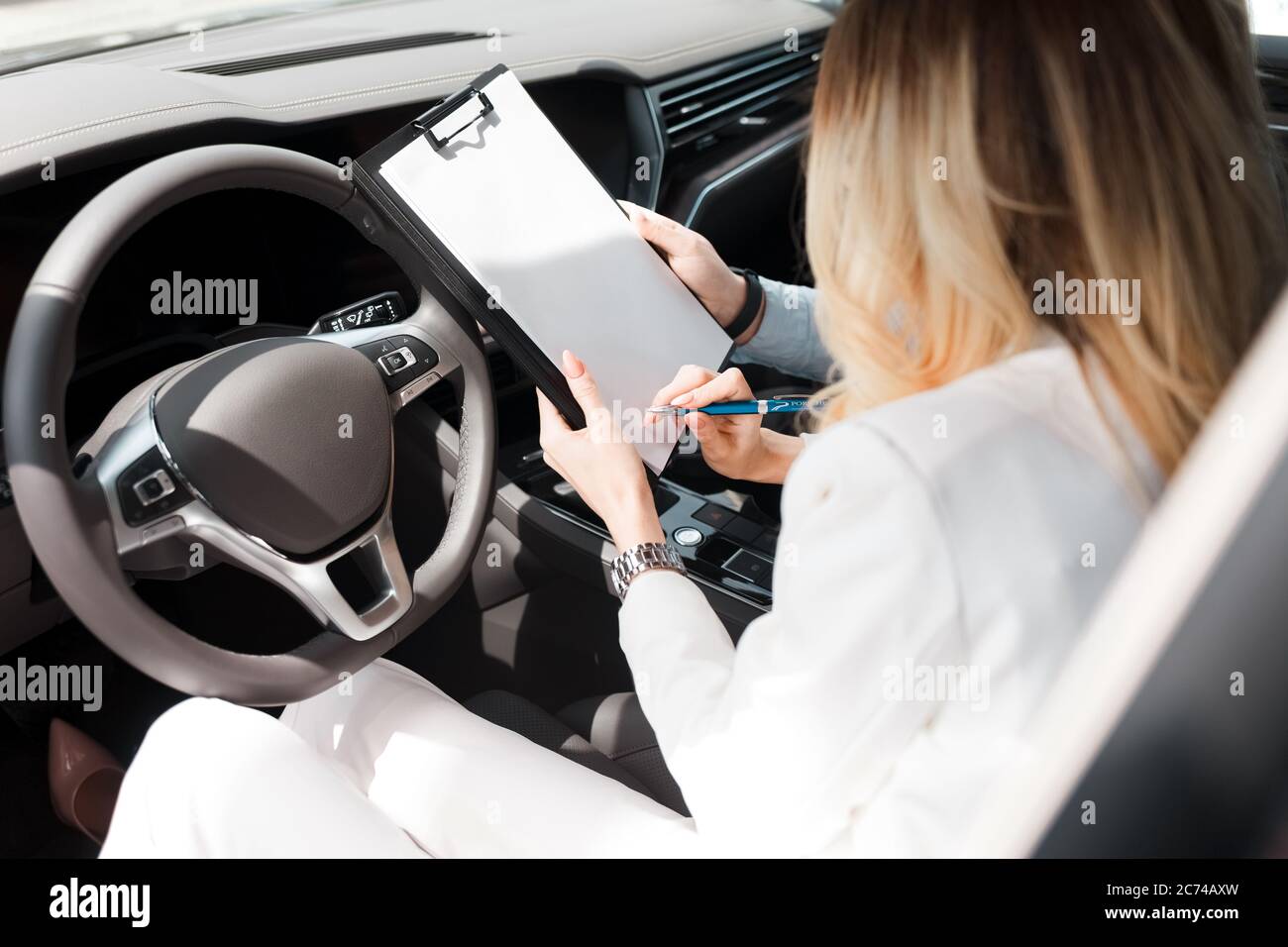 Frau unterzeichnet einen Deal mit einem Autohaus über den Kauf, Leasing-Auto Stockfoto