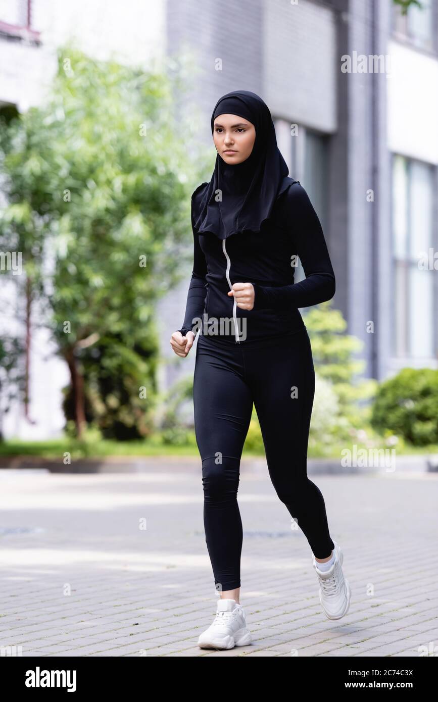 Junge arabische Sportlerin in Hijab und Sportbekleidung, die draußen läuft  Stockfotografie - Alamy