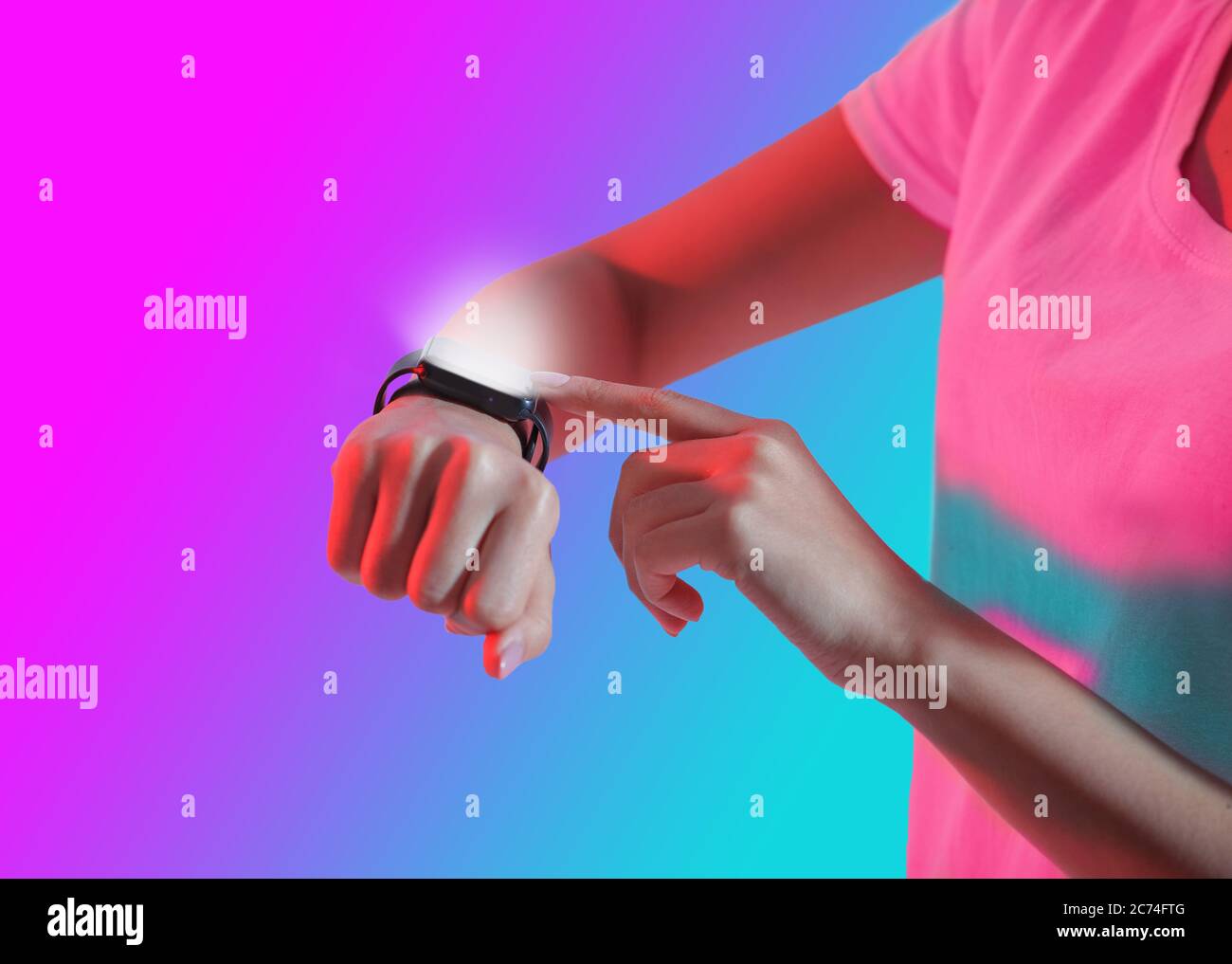 Smart-Gerät zur Hand. Mädchen in T-Shirt drückt Taste auf Smart-Uhr mit Leuchtbildschirm Stockfoto