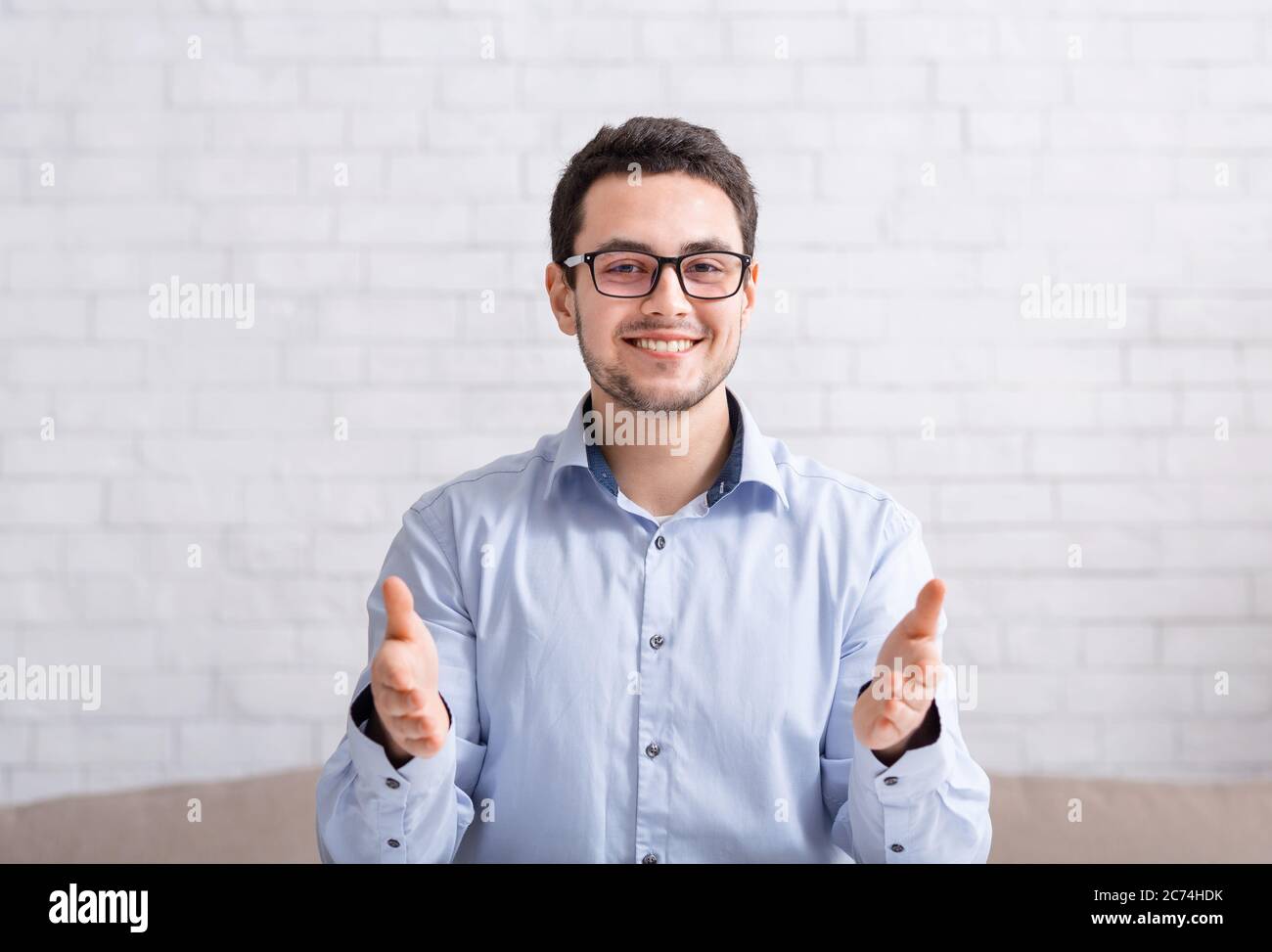 Online-Bewerbungsgespräch. Lächelnder Kerl macht Gesten mit Händen auf Webcam Stockfoto