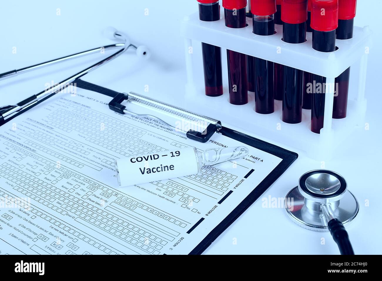 Coronavirus-Impfampulle liegt auf einem Arzttisch, getönte blaue Farbe Stockfoto