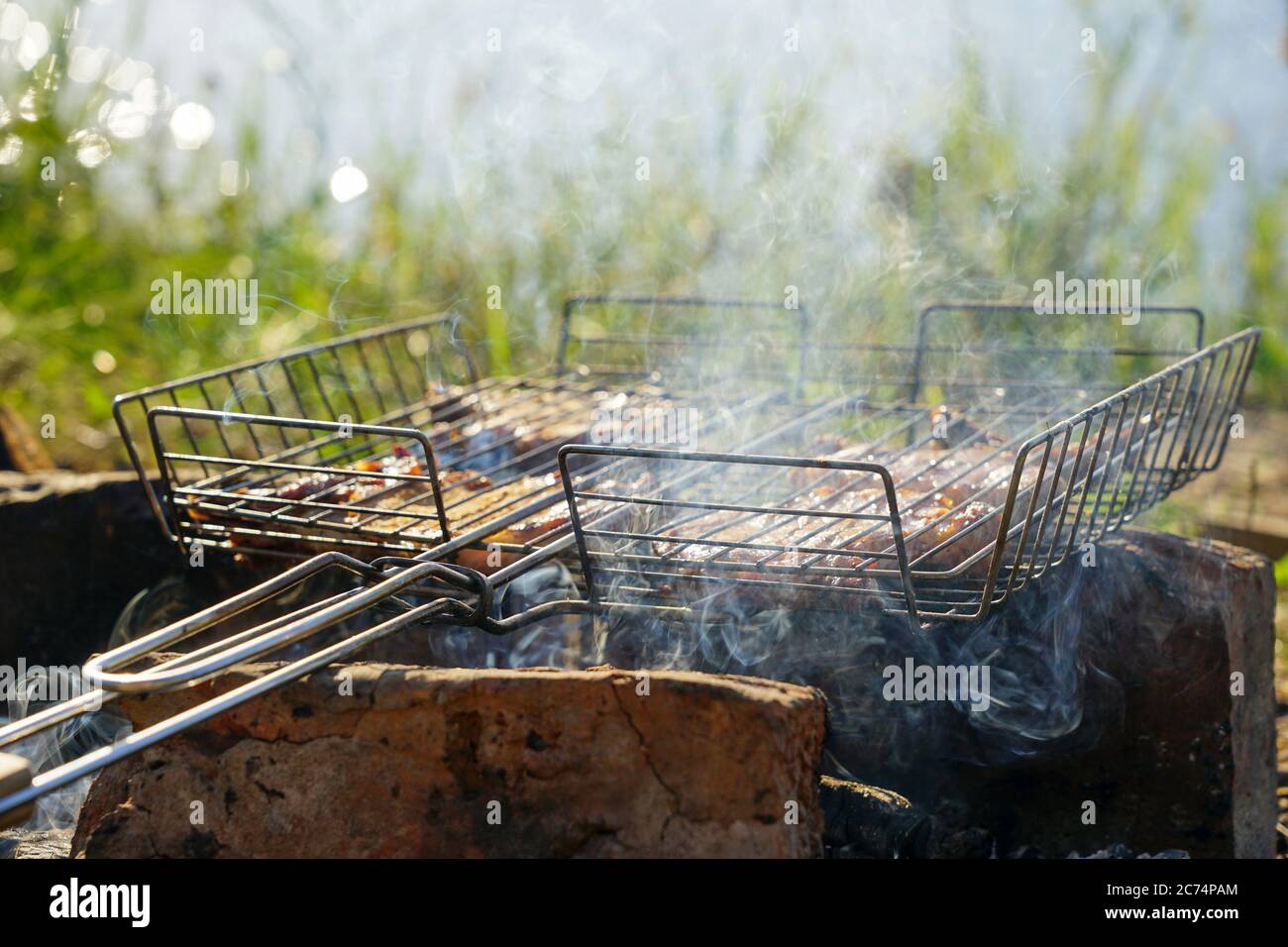 Gegrillte Schweinesteaks lagen über Kohlen auf einem Grill Stockfoto