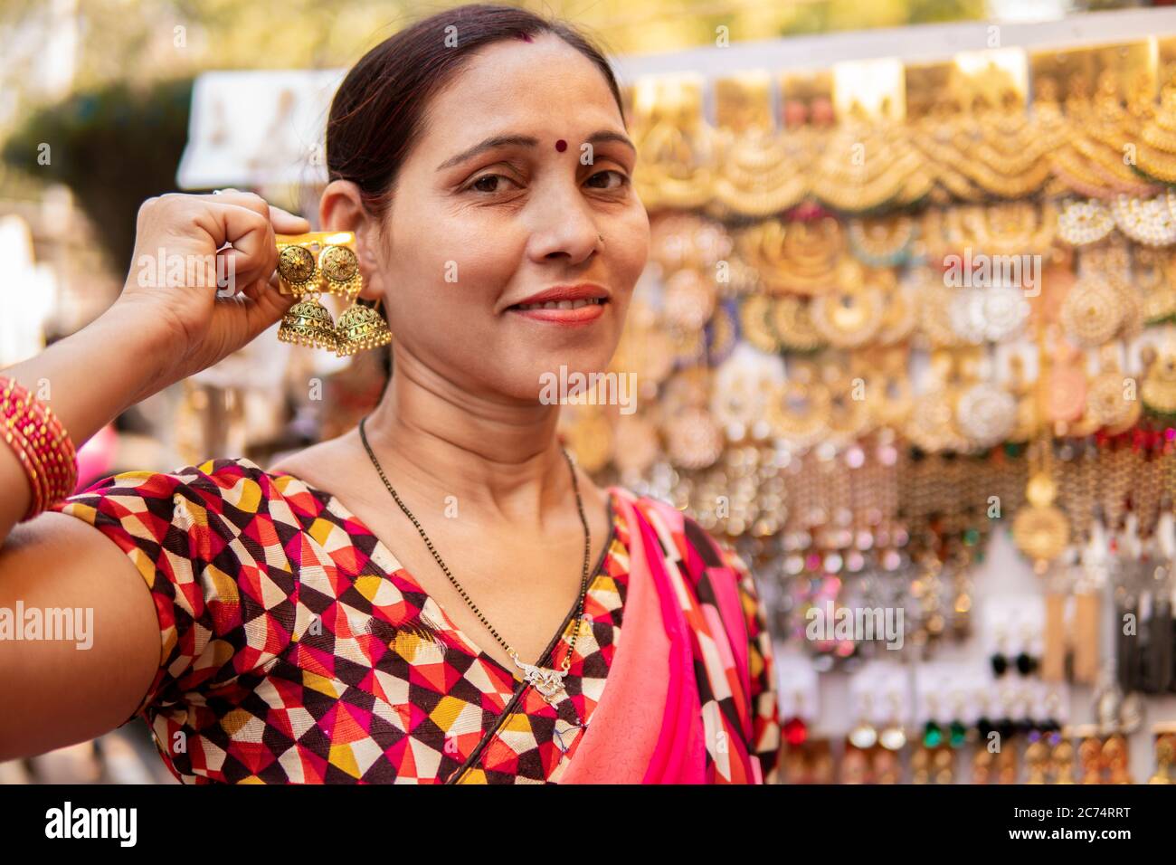 Indische reife Frau suchen und kaufen Ohrringe, Schmuck aus  Outdoor-Straßenmarkt von Delhi, Indien am Tag Zeit. Sie ist in ihrer  traditionellen indischen dres Stockfotografie - Alamy