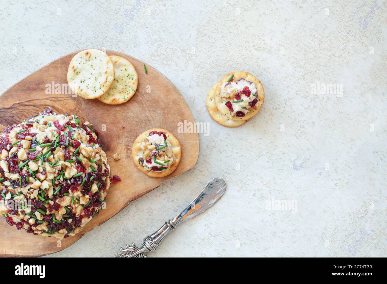 Frisch hausgemachter Cranberry-Käse mit Frischkäse, weißem Cheddar, getrockneten Cranberries, Walnüssen und Schnittlauch auf Marmorboden mit Kopie Stockfoto