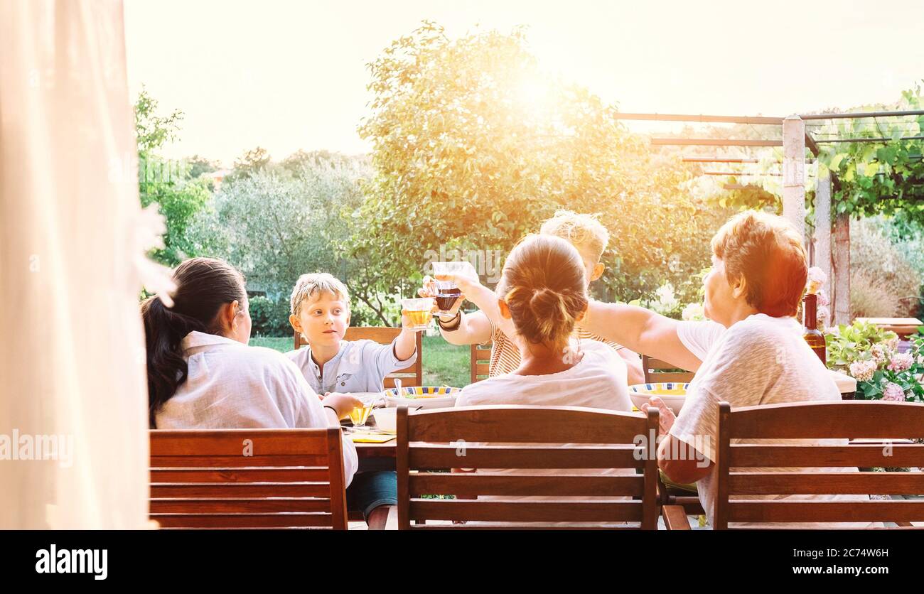 Große Familie mit mehreren Generationen hat Abendessen. Sommerabend im Garten Stockfoto