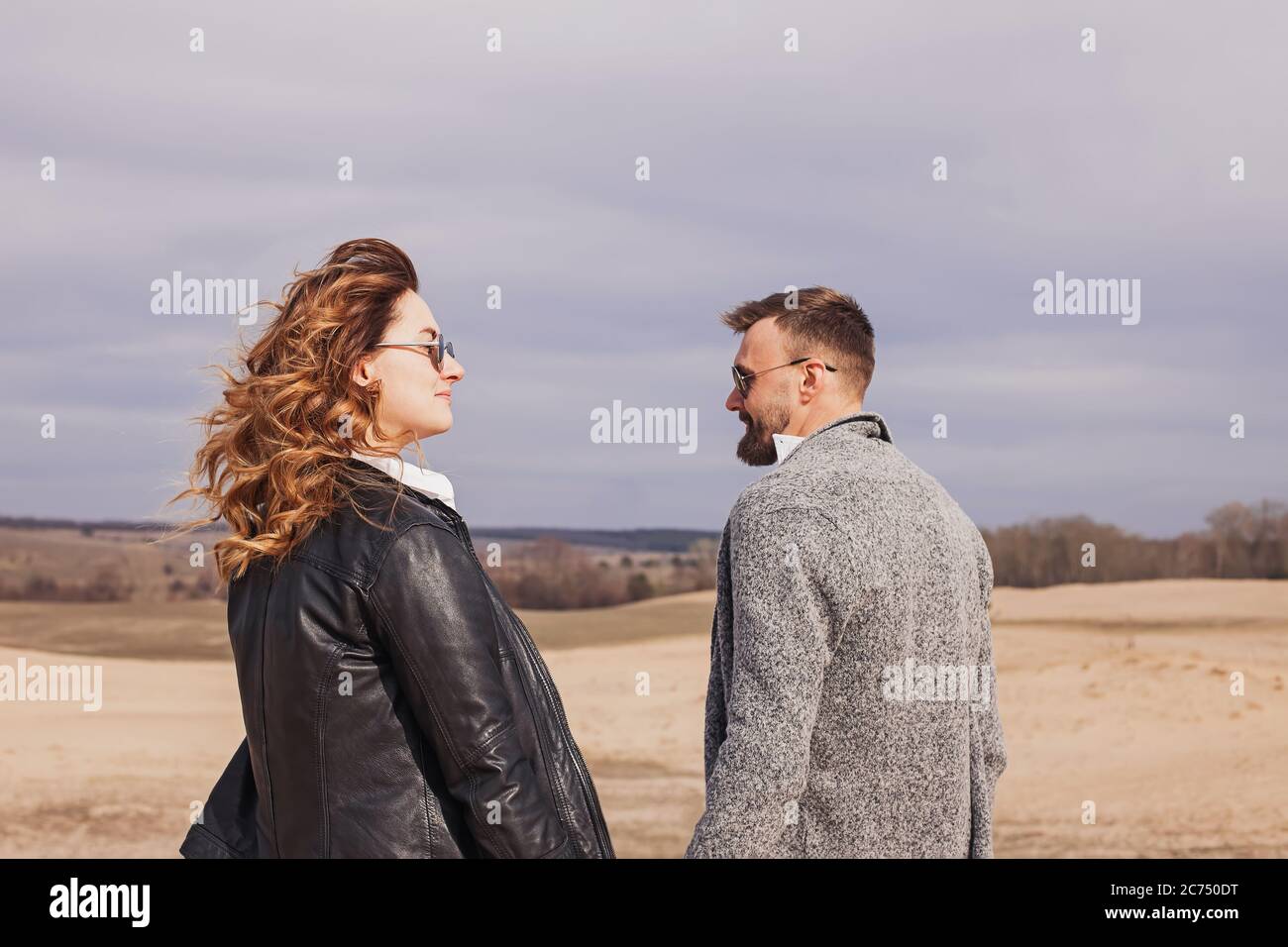 Junge moderne stilvolle Paar im Freien. Frau in Lederjacke und Männer mit Bart Stockfoto