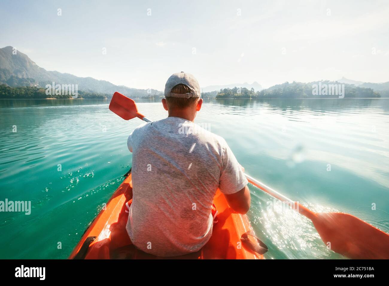 Teenager schwimmt auf dem Kajak auf ruhigem Wasser auf Cheow Lan Lake, Khao Sok Nationalpark, Thailand Stockfoto