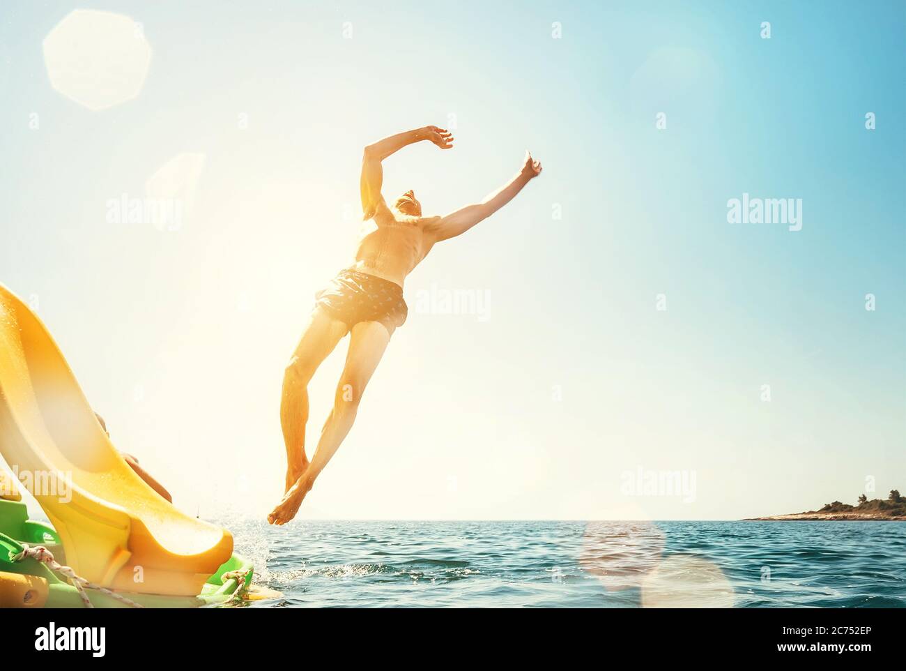 Mann springt rückwärts und springt ins Meer. Happy Beach Urlaub Konzept Bild. Stockfoto