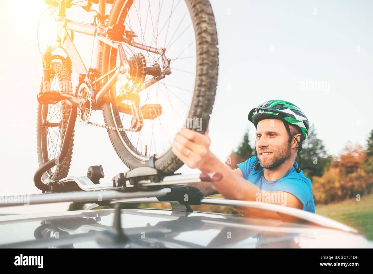 Radfahrer Mann hält sein Fahrrad auf dem Autodach Stockfoto