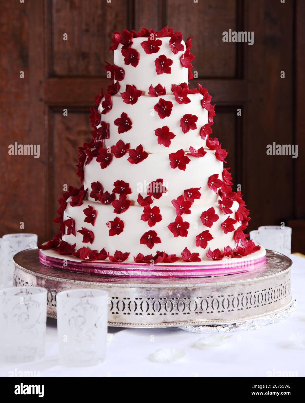 Vierstufiger Hochzeitstorte mit roten Eiszucker-Blüten Stockfoto