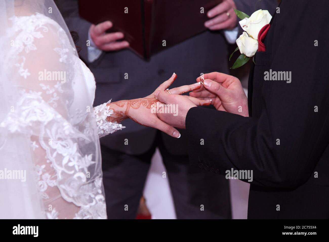 Ring-Zeremonie und Austausch von Eheringen mit Mehndi Brauthochzeit Designs mit Henna-Farbstoff auf die Hände einer Braut. Stockfoto