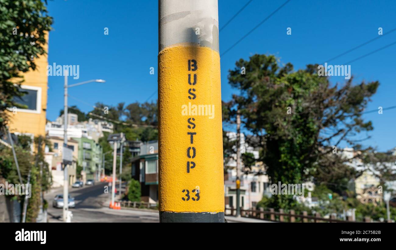 Bushalteschild auf einem Mast mit verschwommenem Hintergrund in San Francisco, Kalifornien, USA Stockfoto