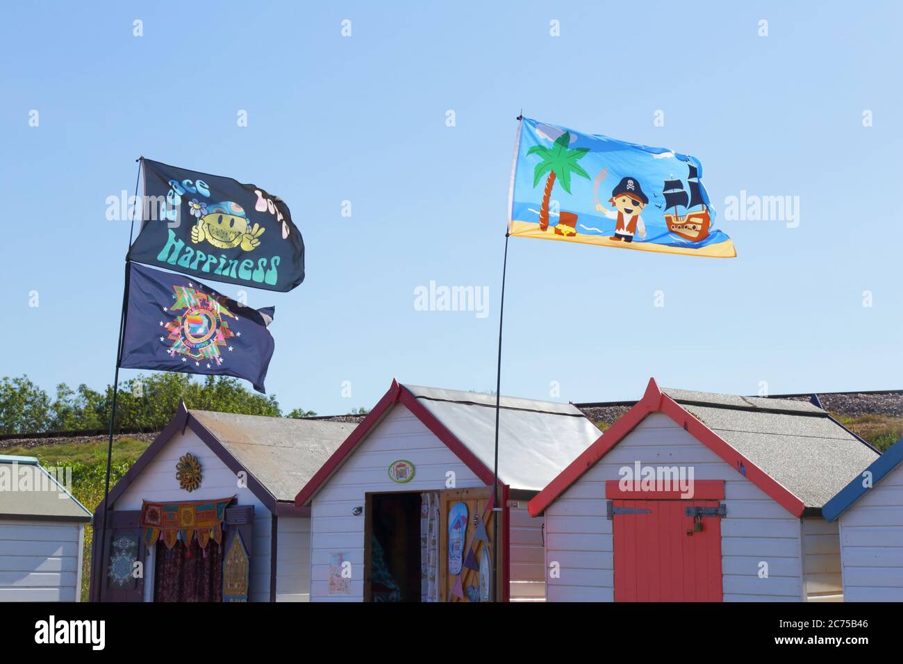 Flaggen auf den Strandhütten in der Küstenstadt Paignton, Devon Stockfoto