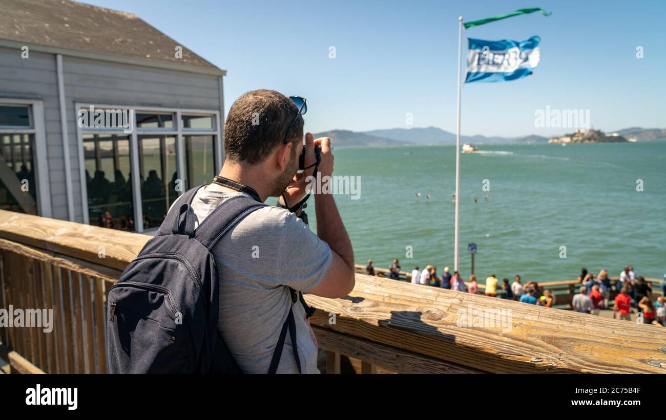 San Francisco, Kalifornien, USA - August 2019: Mann, der Alcatraz Island fotografiert, steht im Pier 39 der Fischerhafen Stockfoto