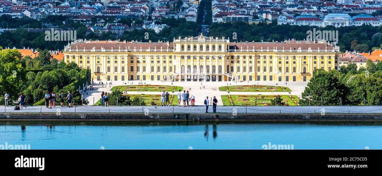 WIEN, ÖSTERREICH - 23. JULI 2019: Schloss Schönbrunn, Deutsch - Schloss Schönbrunn, und großer Parterre - Französischer Garten mit schönen Blumenbeeten. Blick von der Gloriette. Wien, Österreich. Stockfoto