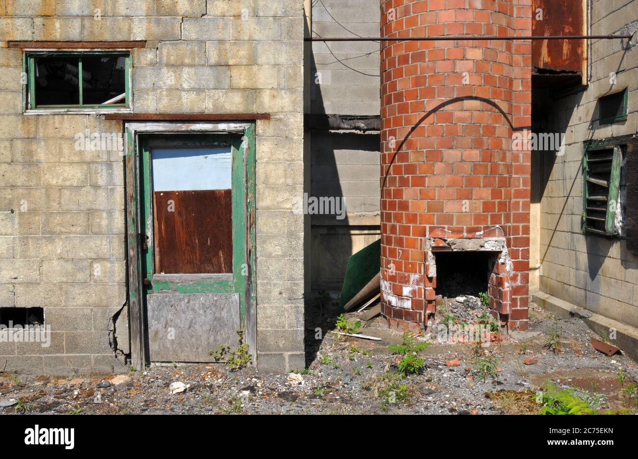 Eine alte Tür und ein Ziegelrauchkestack im ehemaligen Pierce-Arrow-Automobilfabrik-Komplex in Buffalo, New York, entworfen vom Architekten Albert Kahn. Stockfoto