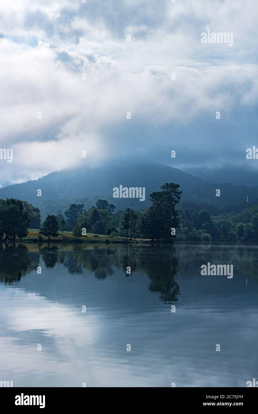 Spiegelung von Wolken, Nebel, Bergen und Bäumen erzeugt Spiegelsymmetrie am Beaver Lake in Asheville, NC, USA Stockfoto