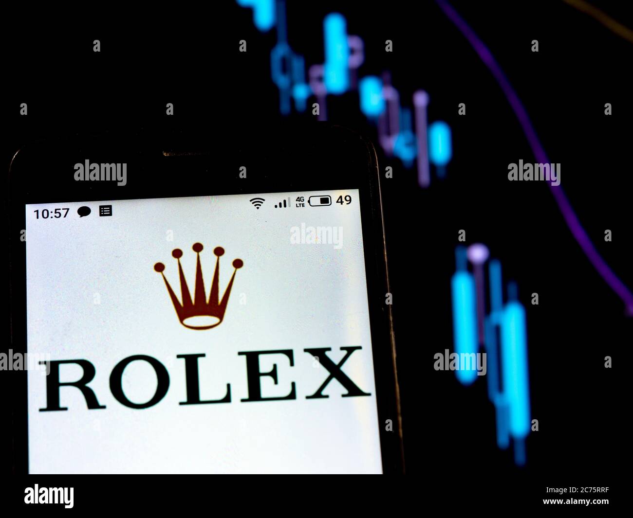 In dieser Abbildung wird Rolex Logo auf einem Smartphone auf dem Hintergrund einer Grafik mit fallenden Kurven angezeigt. Nach internationalen Medienberichten während der Coronavirus-Epidemie COVID-2019 stellte Rolex die Produktion ein. Stockfoto