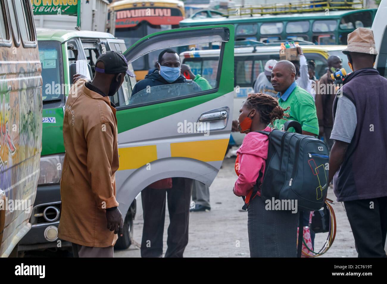 Nairobi, Kenia. Juli 2020. Ein öffentlicher Verkehrsdienstleister mit Gesichtsmask spricht mit einem Passagier am Busbahnhof Machakos Country.der öffentliche Verkehr innerhalb und außerhalb Nairobis begann sich langsam zu normalisieren, nachdem viele Busse und Lieferwagen die Maßnahmen des Gesundheitsministeriums eingehalten hatten, um die Ausbreitung von Covid-19 einzudämmen. Busse und Lieferwagen müssen nur die Hälfte ihrer Kapazität transportieren, um die sozialen Distanzierungsregeln einzuhalten und alle Passagiere müssen Gesichtsmasken tragen. Kredit: SOPA Images Limited/Alamy Live Nachrichten Stockfoto