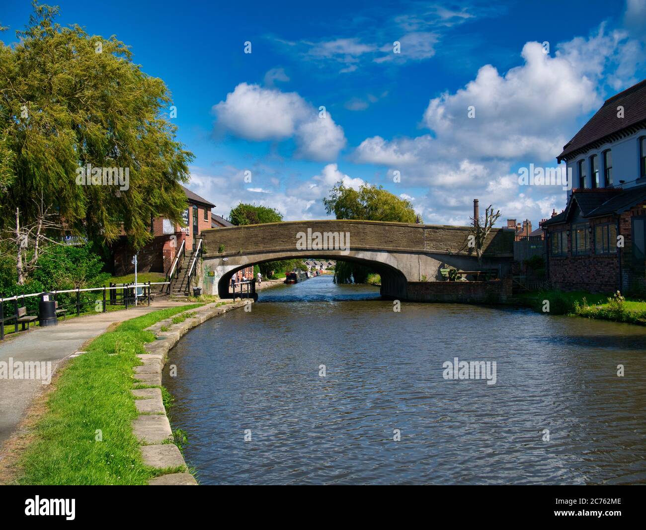 Burscough Bridge der Straßenverkehr auf der A59 über den Leeds zum Liverpool Canal in Burscough, Lancashire, Großbritannien - aufgenommen an einem sonnigen Sommertag. Stockfoto