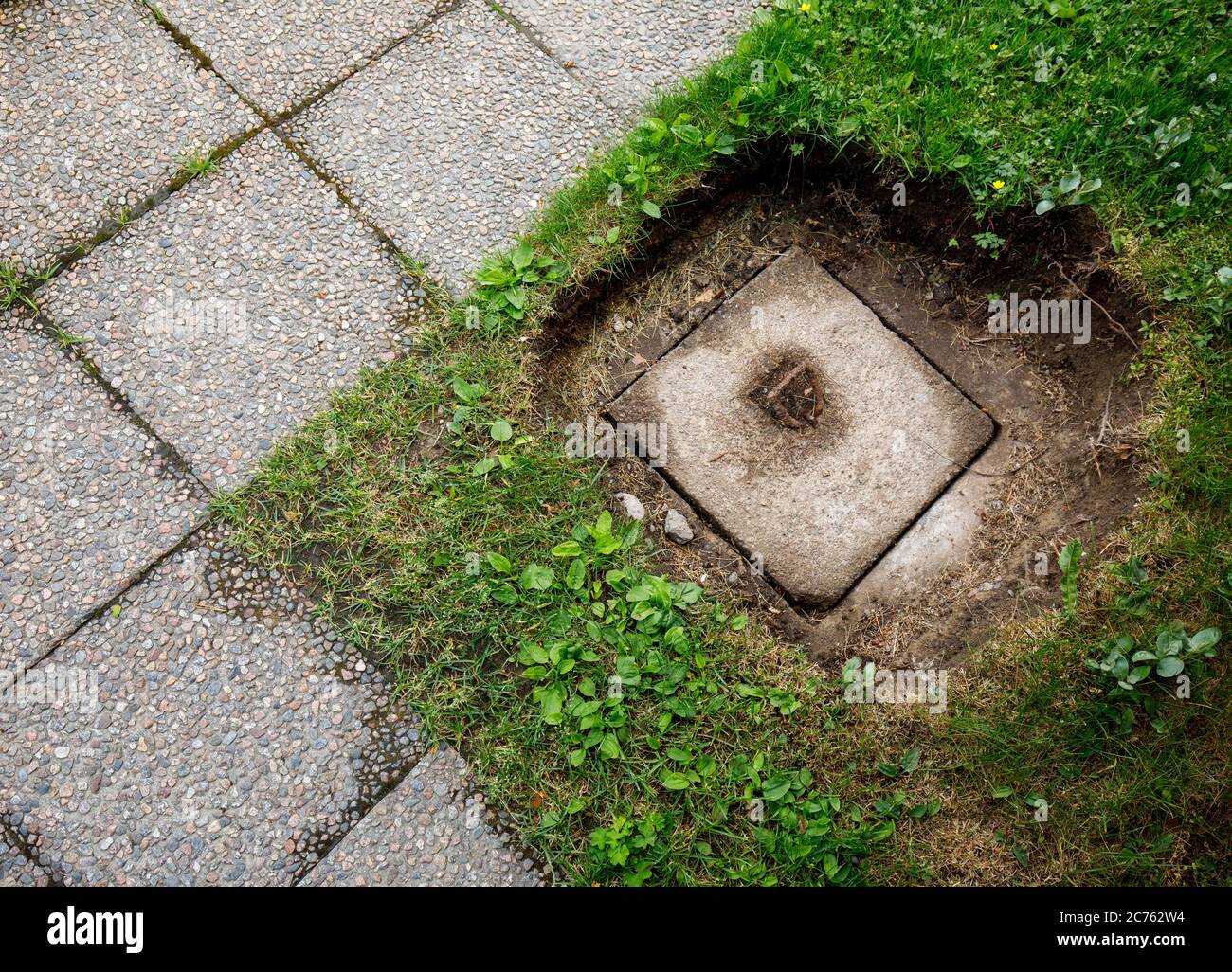 Betonabfallentsorgung gut Abdeckung unter Rasen ausgegraben Stockfoto