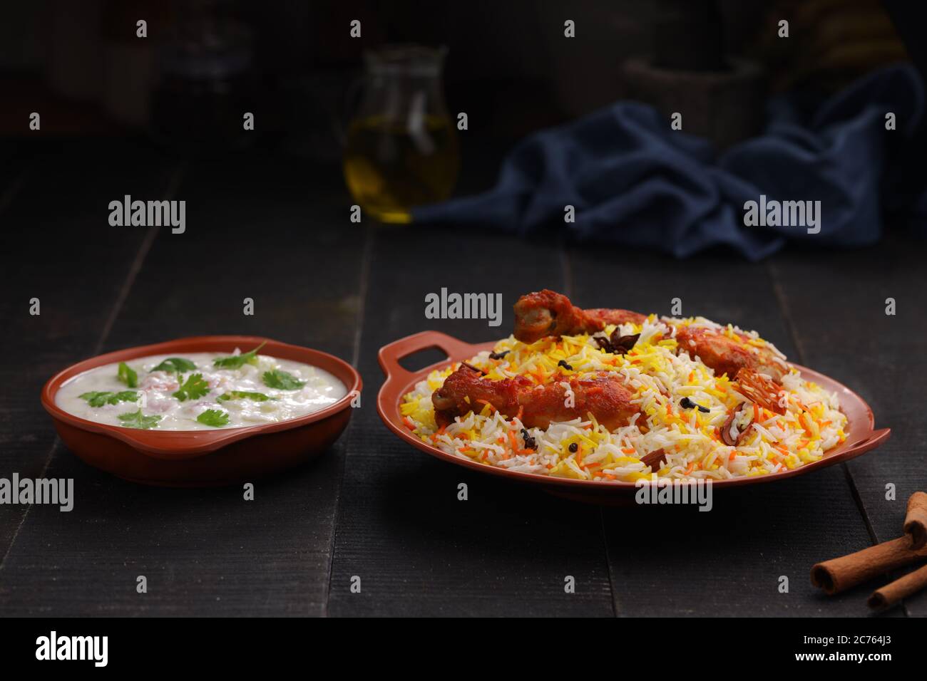 Huhn Biryani , Tandoori Huhn mit Basmathi Reis und Raita als Beilage in einer Terrakotta Steingut mit schwarzem Hintergrund oder Textur angeordnet Stockfoto