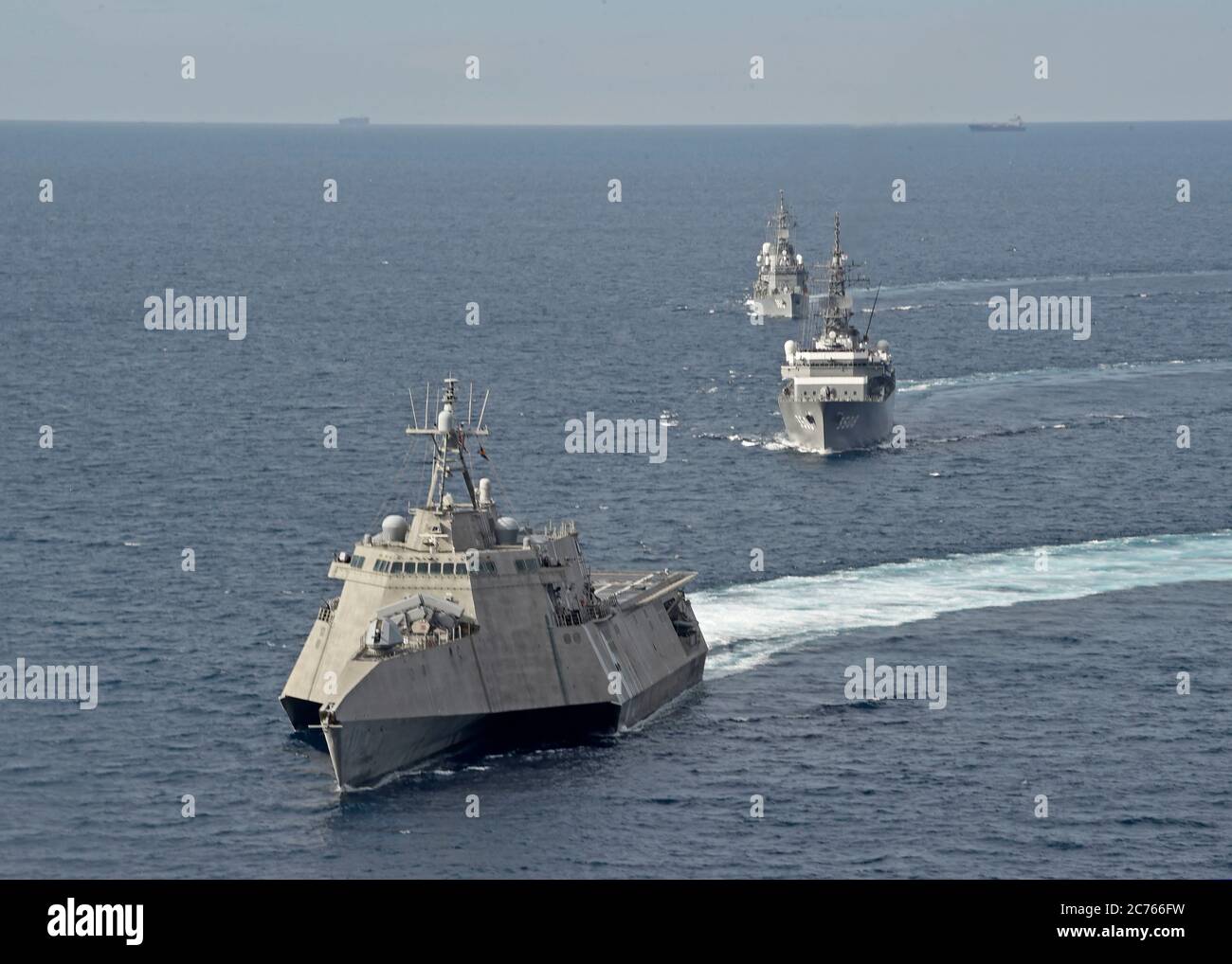 Das US Navy Independence-Variant Littoral Combat Ship USS Gabrielle Giffords, links, während einer gemeinsamen Patrouille mit dem Japan Maritime Self-Defense Kashima Class Kadettentrainingsschiff JS Kashima und Force Hatsuyuki-Class Zerstörer JS Shimayuki in International Waters 23. Juni 2020 im Südchinesischen Meer. Stockfoto
