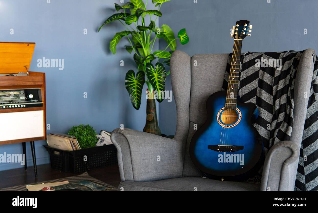 Home Interieur einer der Ecken des Raumes. Nahaufnahme eines bequemen Sessels mit Kart und Gitarre im Zimmer. Stockfoto