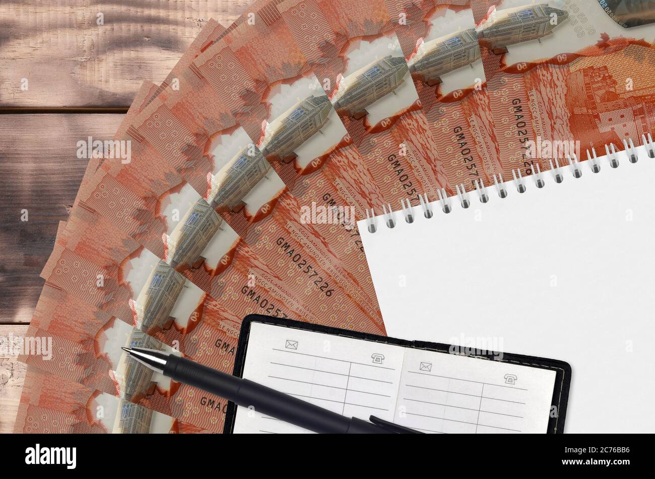 50 Kanadische Dollar Scheine Fächer und Notizblock mit Kontaktbuch und schwarzem Stift. Konzept der Finanzplanung und Geschäftsstrategie. Rechnungslegung und Investitionen Stockfoto