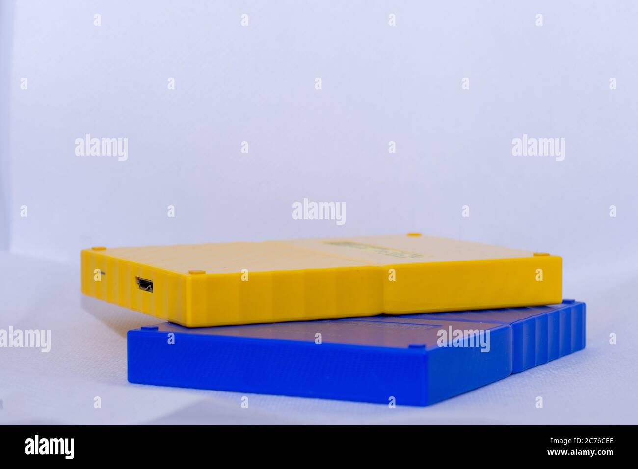 Gelbe und blaue tragbare usb-Festplatten auf isoliertem weißem Hintergrund. Stockfoto