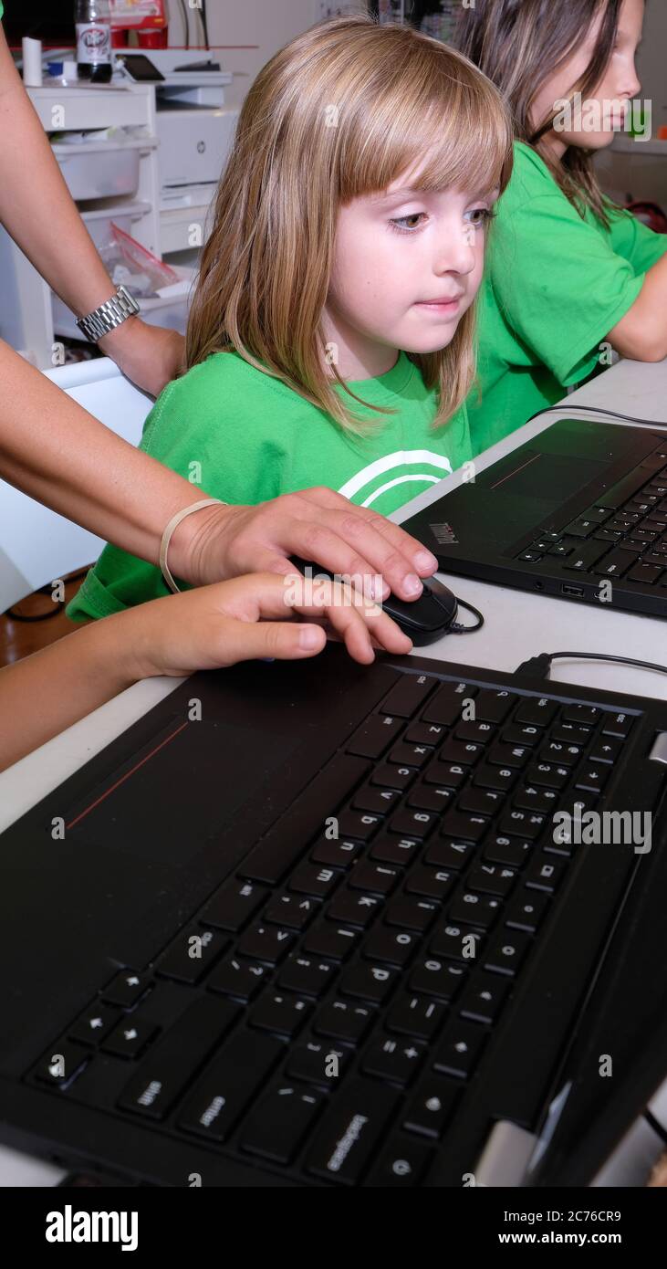 Tageslager. Brooklyn, New York. Kinder-Technologie-Camp. Kinder arbeiten an der Computerprogrammierung mit Lehrer. Modell freigegeben. Stockfoto