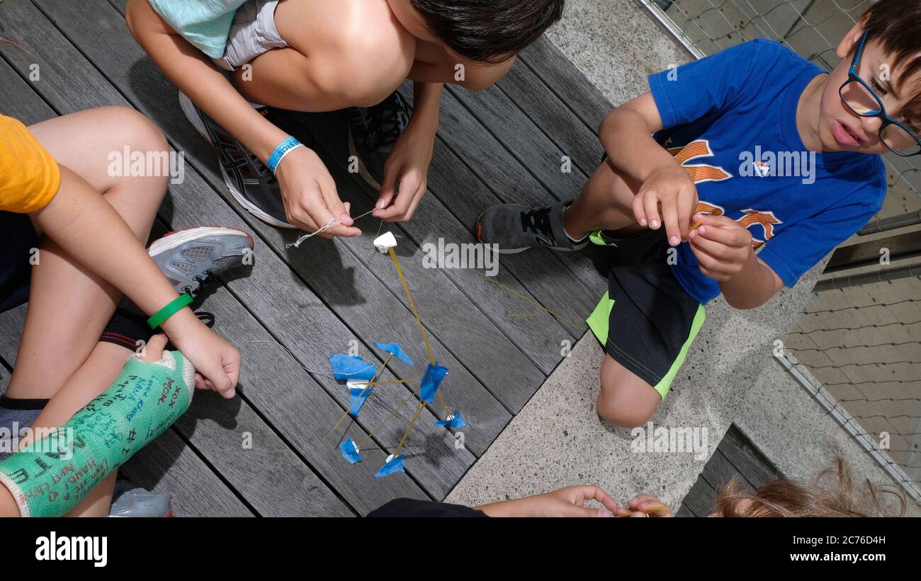 Tageslager, Brooklyn, New York City. Kinder bauen Türme aus Spaghetti, um mehr über Teamwork und Balance zu erfahren. Stockfoto