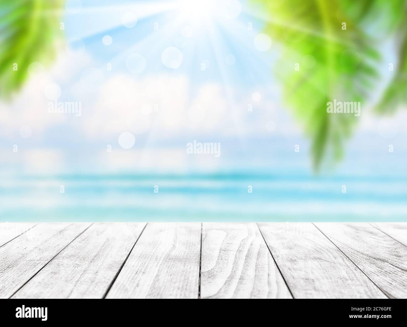Verschwommener blauer Himmel und Meer mit Bokeh-Licht und Blättern von Kokospalme. Landschaft des tropischen Sommers. Sommerurlaub Konzept. Stockfoto
