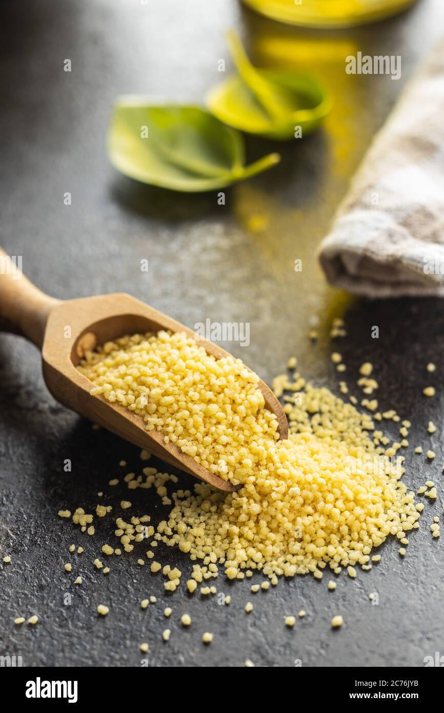 Getrocknete gelbe Couscous in Holzlöffel. Stockfoto