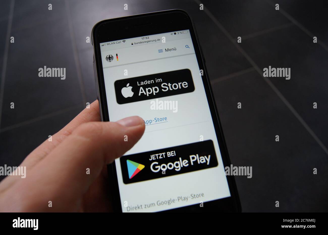 Corona Warn App Website der Bundesregierung auf einem Smartphone zeigt Download-Optionen von Apples App Store und dem Google App Store. Stockfoto
