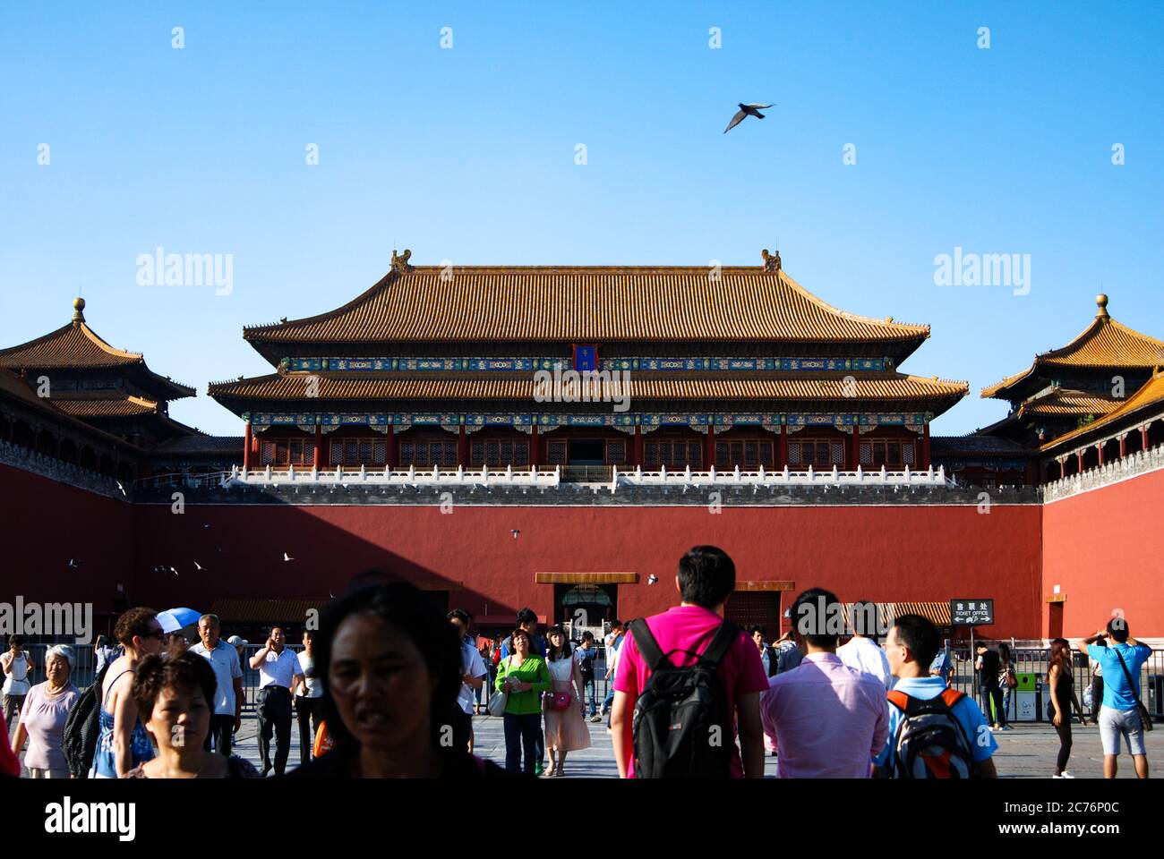 Ein Blick in die Verbotene Stadt in Peking, China an einem sonnigen Tag mit blauem Himmel und einigen Touristenmassen, ein Vogel vorbei. Stockfoto