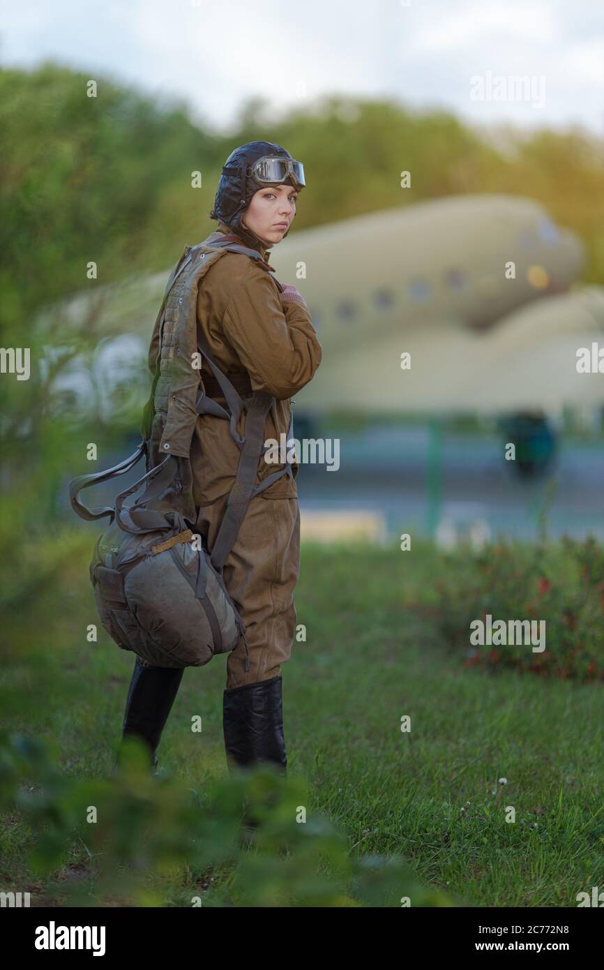 Eine junge Pilotin in Uniform der sowjetischen Armee Piloten während des Zweiten Weltkriegs Militär-Shirt mit Schulterriemen eines Major, Fallschirm, Flug helme Stockfoto