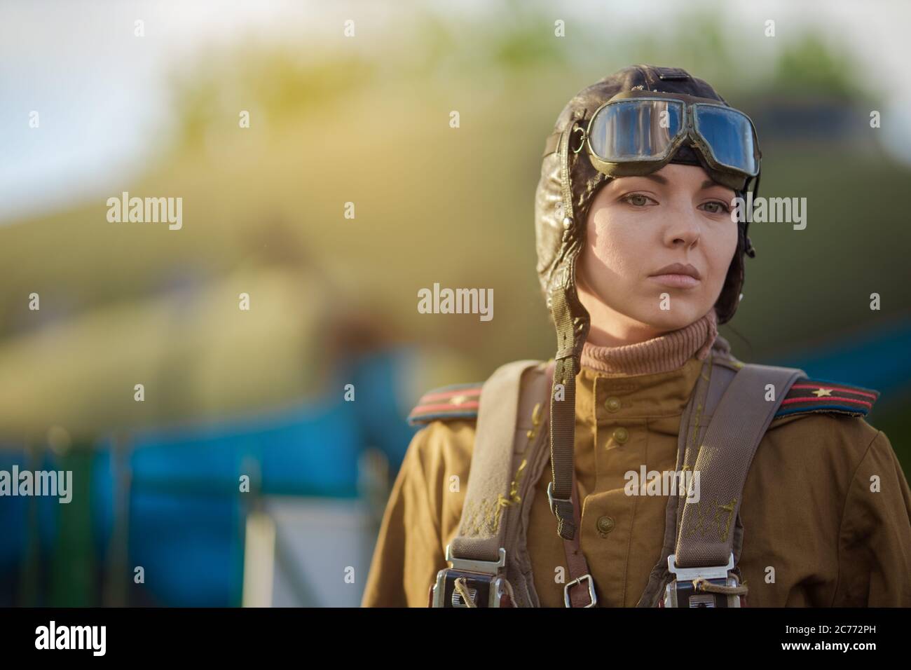 Eine junge Pilotin in Uniform der sowjetischen Armee Piloten während des Zweiten Weltkriegs Militär-Shirt mit Schulterriemen eines Major, Fallschirm, Flug helme Stockfoto