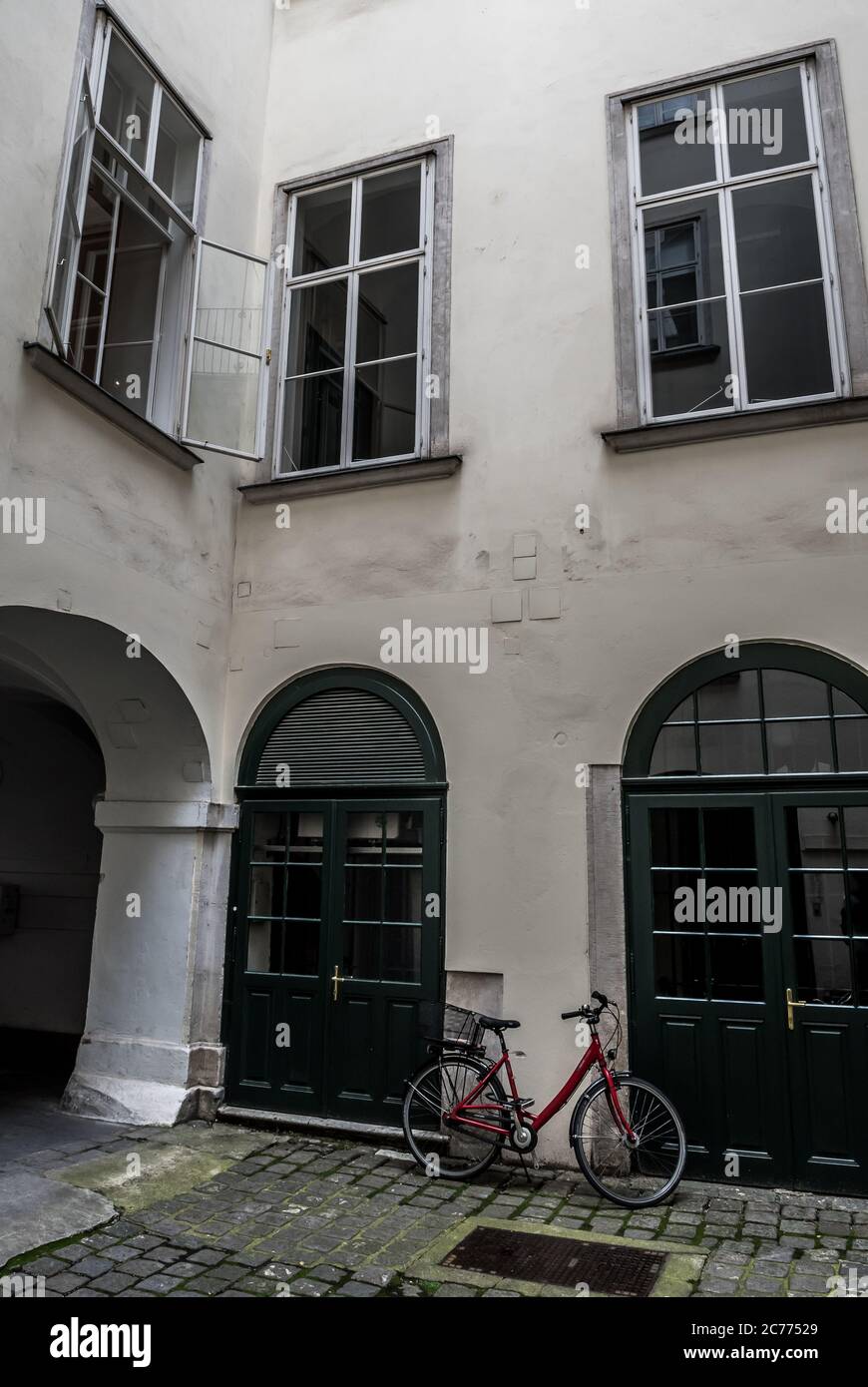 Hinterhof eines historischen Hauses mit EINEM gesperrten Vintage-Fahrrad in der Innenstadt von Wien in Österreich Stockfoto