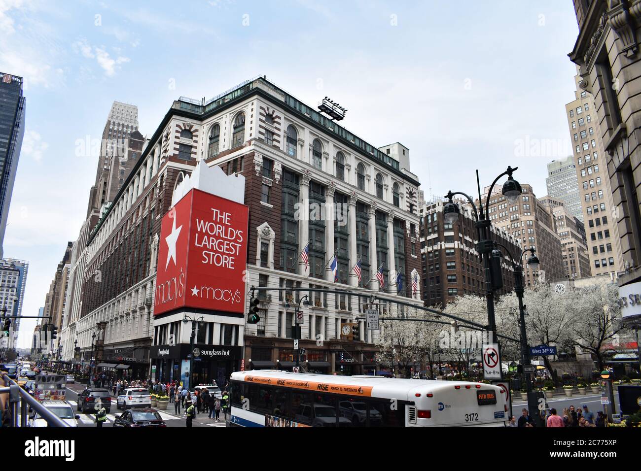 Blick auf Macy's Kaufhaus von der Kreuzung 34th Street an 6th Avenue, Herald Square. Verkehr, Bus und Fußgänger sind in Schuss. Stockfoto