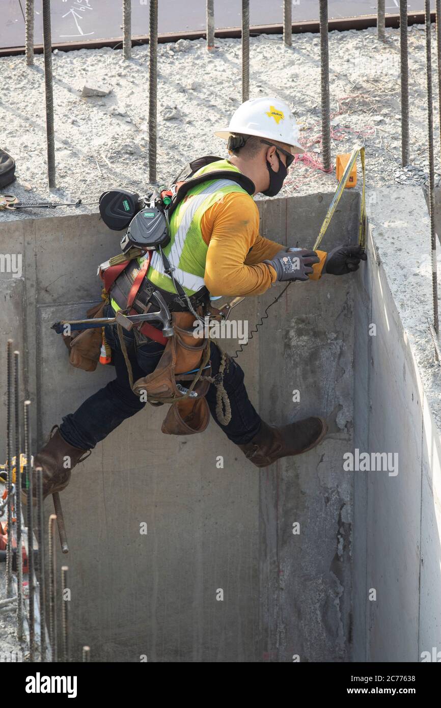 Austin, TX USA 14. Juli 2020: Bauarbeiter Emmanuel Quevedo bereitet während einer achtstündigen Schicht bei der 105-Grad-Hitze in Texas einen Aufzugsschacht für zusätzliche Versteifungen vor. Die Crews befinden sich im zweiten Stock eines geplanten 53-stöckigen Gebäudes, um Vorkehrungen gegen die Coronavirus-Pandemie zu treffen. Stockfoto