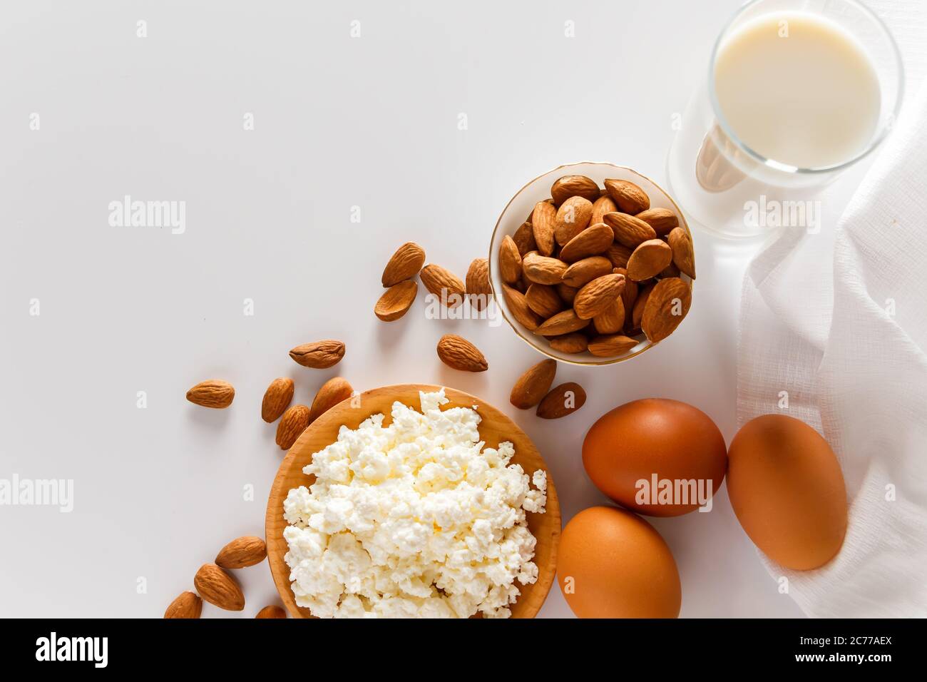 Rustikale hausgemachte Protein ausgewogene Ernährung Lebensmittel. Hüttenkäse, Eier, Nüsse und Milch auf weißem Hintergrund. Stockfoto