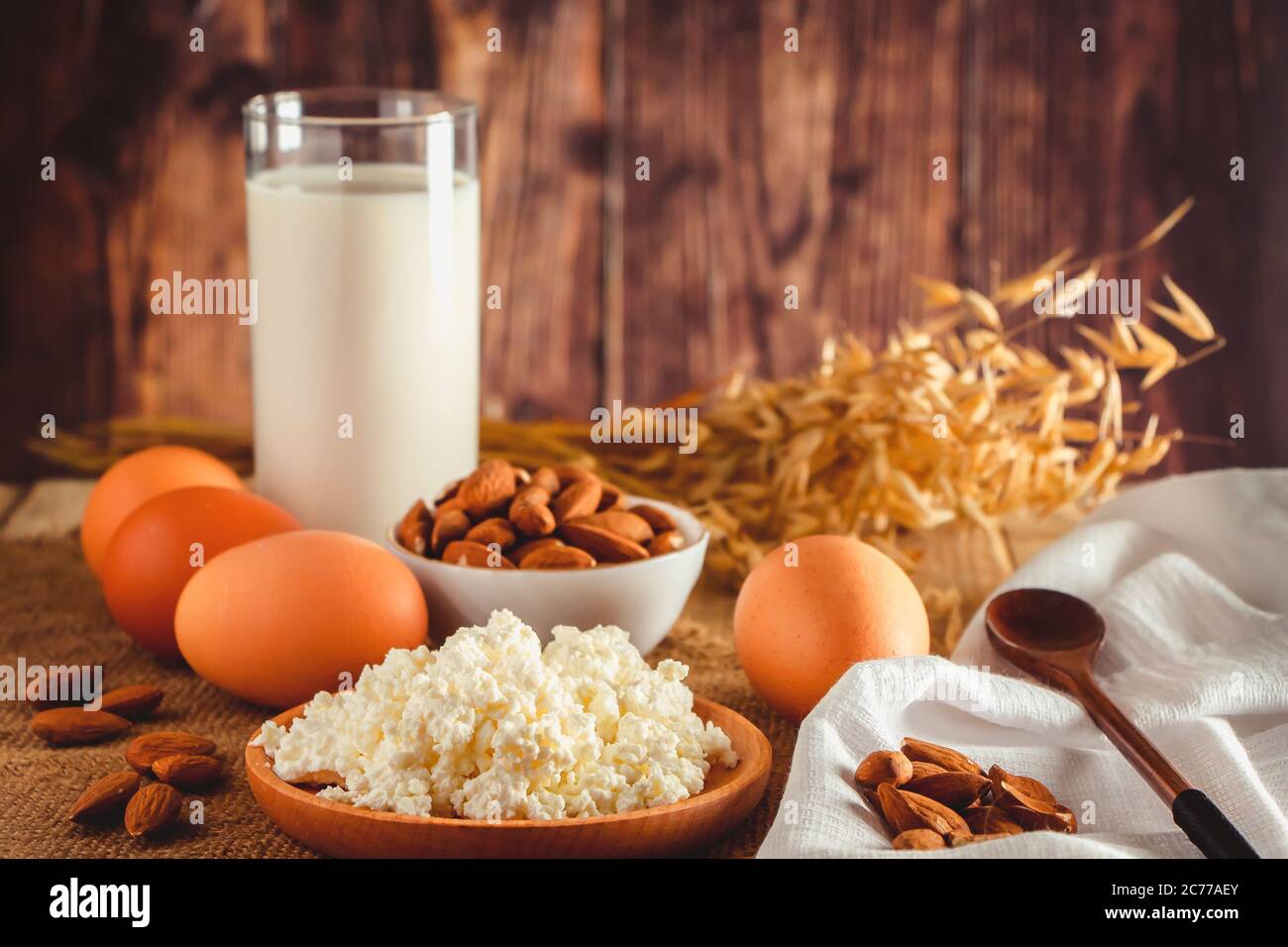 Rustikale hausgemachte Protein ausgewogene Ernährung Lebensmittel. Hüttenkäse, Eier, Nüsse und Milch auf einem Holzhintergrund. Stockfoto