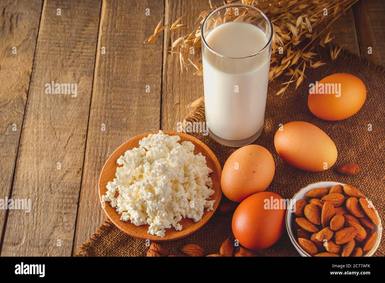 Rustikale hausgemachte Protein ausgewogene Ernährung Lebensmittel. Hüttenkäse, Eier, Nüsse und Milch auf einem Holzhintergrund. Für Text platzieren Stockfoto