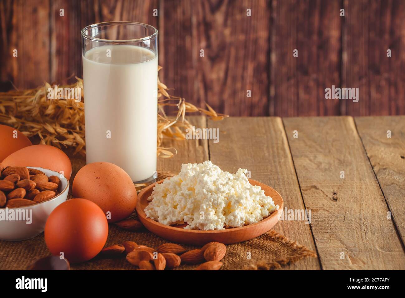 Rustikale hausgemachte Protein ausgewogene Ernährung Lebensmittel. Hüttenkäse, Eier, Nüsse und Milch auf einem Holzhintergrund. Für Text platzieren Stockfoto