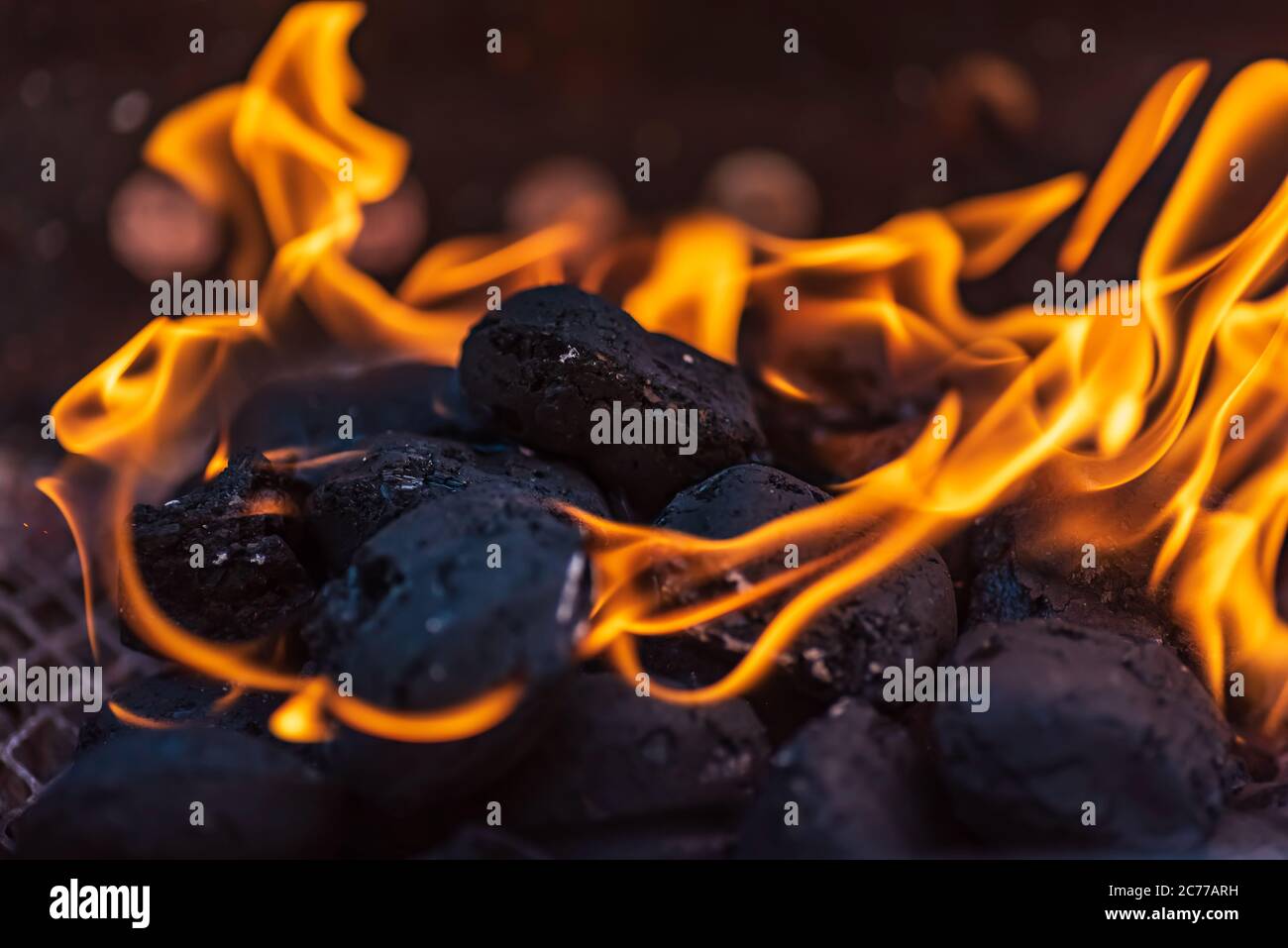 Grillbriketts, die brennen und warten, zum Grillen glüht zu werden,  Briketts werden aus Braunkohle, Torf, Holzkohle oder Kohlestrub hergestellt  Stockfotografie - Alamy