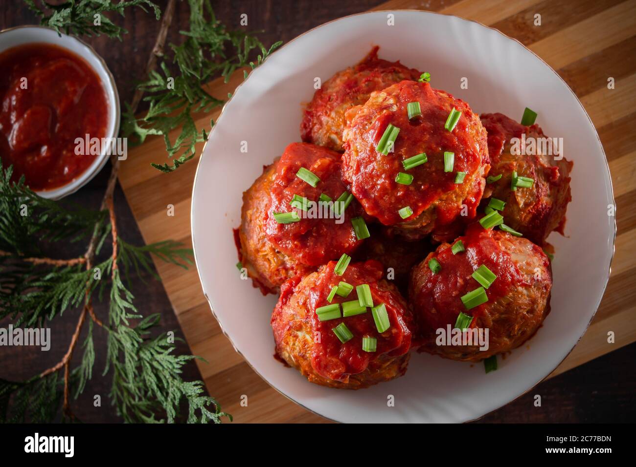 Fleischbällchen mit Tomatensauce und Kräutern. Draufsicht auf einem Teller mit Fleischbällchen und Sauce Stockfoto